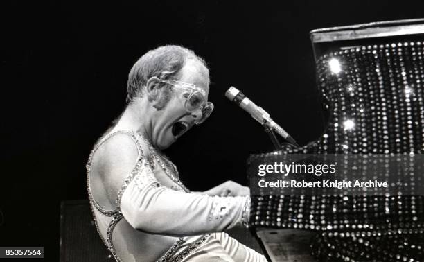 Photo of Elton JOHN; Elton John performing on stage, piano, profile