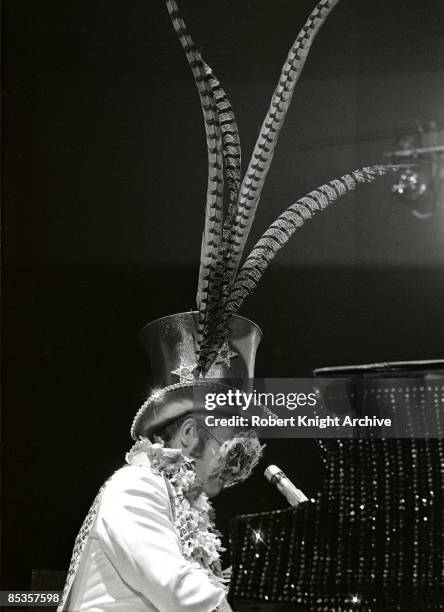 Photo of Elton JOHN; Elton John performing on stage, hat with feathers