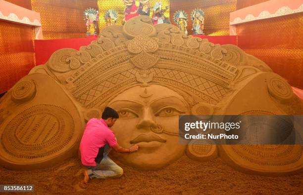 Sand Artist Manas Kumar Sahoo from Puri, Orissa gives a finishing touch to a sand sculpture representing Durga of Durga Puja celebration at Nepali...