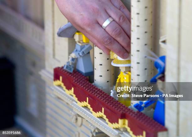 Royal Warrant of Appointment to Her Majesty The Queen Milliner Rachel Trevor Morgan puts the finishing touches to Legoland Windsor Resort's 10cm...