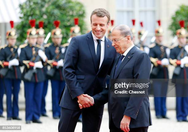 French President Emmanuel Macron welcomes Libanese President Michel Aoun prior to their meeting at the Elysee Presidential Palace on September 25,...
