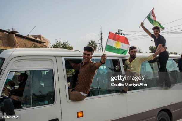 Kurdish men hold Kurdistan flags on their way to vote in a referendum to decide on independence from Iraq and the establishment of Kurdistan as a...