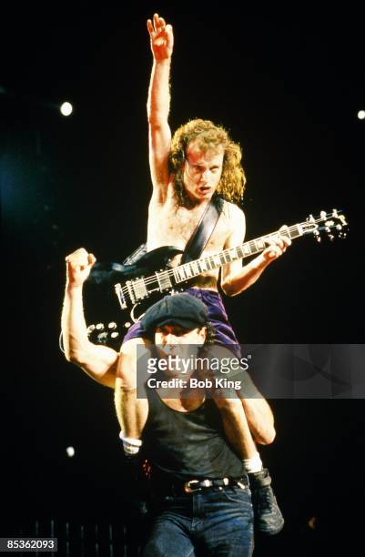 Photo of AC DC and Brian JOHNSON and Angus YOUNG and AC/DC; Angus Young sitting on Brian Johnson's shoulders performing live onstage
