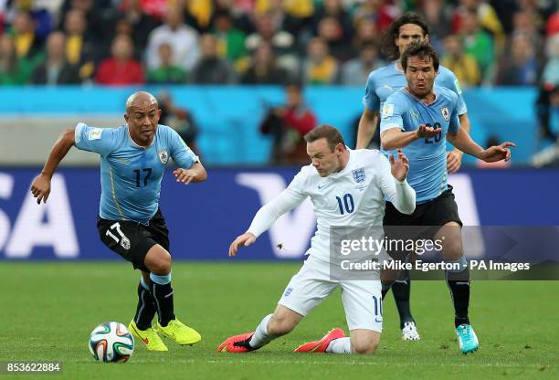 England's Wayne Rooney in action with Uruguay's Alvaro Gonzalez and Uruguay's Egidio Arevalo Rios during the Group D match the Estadio do Sao Paulo,...