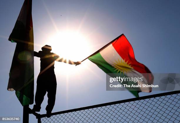 Supporter waves the Kurdish flag during a rally for the upcoming referendum for independence of Kurdistan on September 22, 2017 in Erbil, Iraq. The...