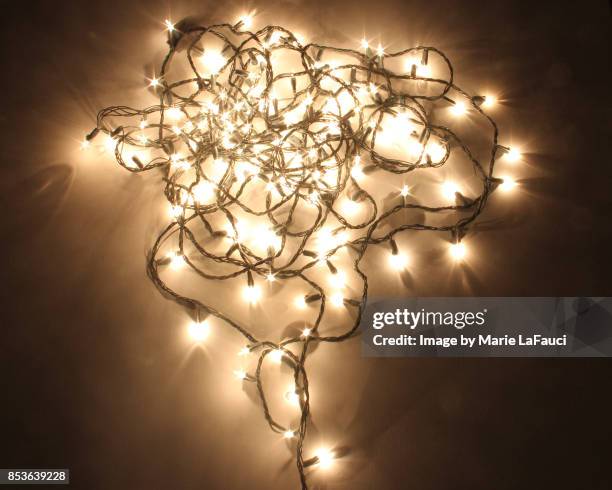 messy heart shaped christmas lights lit up in the dark - haz de luz fotografías e imágenes de stock