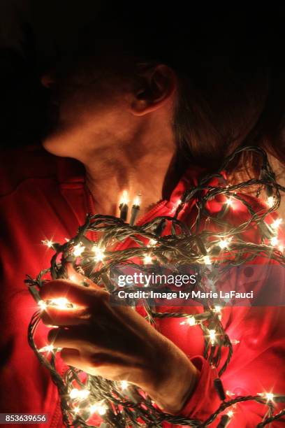 woman with tangled christmas lights on - tangled christmas lights stock pictures, royalty-free photos & images