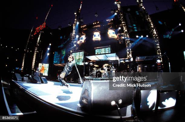 Photo of U2, Bono performing live onstage on Zoo TV Zooropa tour, showing stage set and lighting