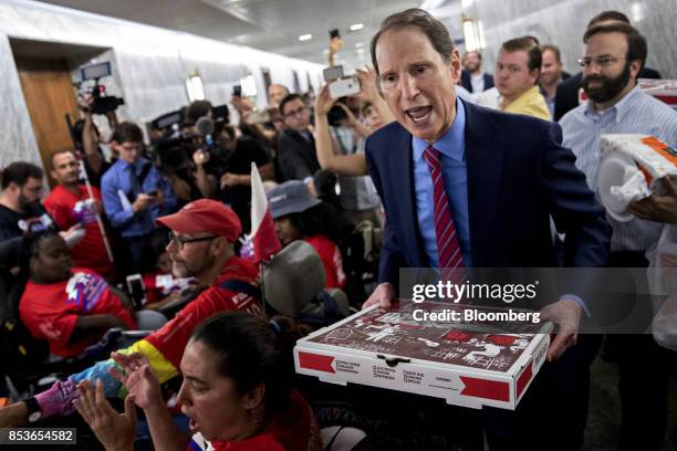 Senator Ron Wyden, a Democrat from Oregon and ranking member of the Senate Finance Committee, speaks while delivering pizza to disability rights...