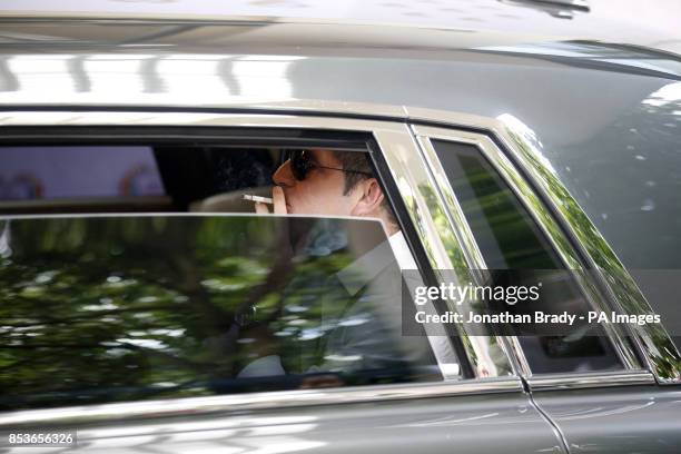 Simon Cowell smoking as he arrives in his chauffeur driven car to the Savoy Hotel, London, to attend the Health Lottery Tea Party charity fundraiser.