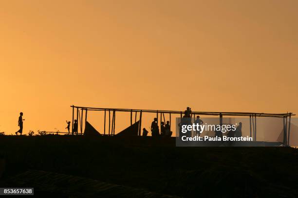 People are seen at a mosque under construction at sunset at Kutupalong camp September 25, 2017 in Kutupalong, Cox's Bazar, Bangladesh. Over 429,000...