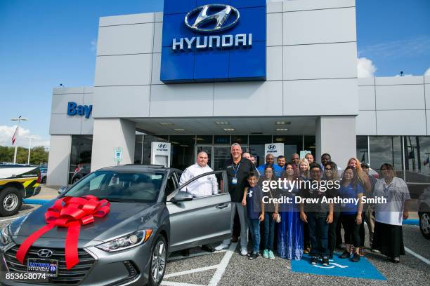 Henry Rogers poses with his family and members of Baytown Hyundai after receiving a 2018 Hyundai Elantra September 25, 2017 in Baytown, Texas. Henry...