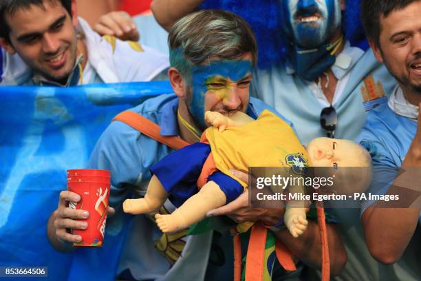 Uruguay fan biting a doll wearing a Brazil shirt before the FIFA World Cup, Round of 16 match at the Estadio do Maracana, Rio de Janeiro, Brazil.