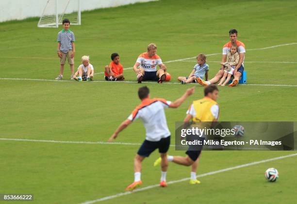 Robin van Persie and Dirk Kuyt sit watching training with their children at Estadio Jose Bastos Padilha, Rio de Janeiro, Brazil.