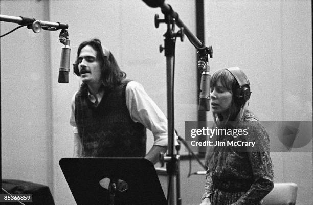 Circa 1970: Photo of James TAYLOR and Joni MITCHELL; w/ James Taylor recording backing vocals on Carole King's album Tapestry