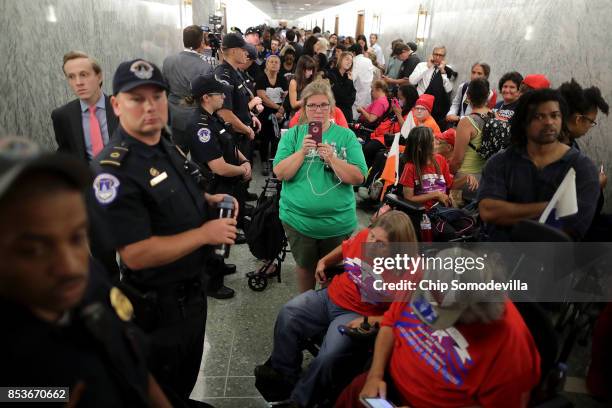 Dozens of U.S. Capitol Police officers line the hallway and keep watch on people waiting to attend the Senate Finance Committee hearing about the...