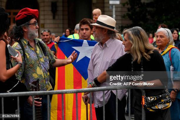 People against independence in Catalonia discuss with a pro-independence supporter, sporting the traditional Catalan hat "Barretina" , on September...