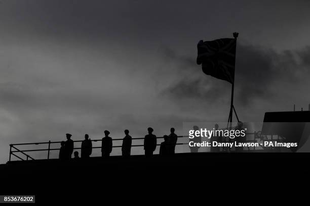 Silhouettes on deck as Queen Elizabeth II officially named Royal Navy's new aircraft carrier HMS Queen Elizabeth during a visit to Rosyth dockyard in...