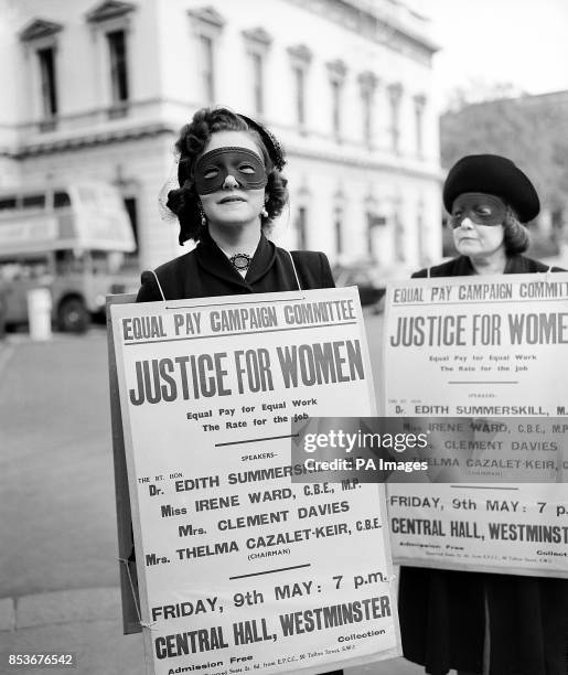 Masked woman parades with a placard in the Strand, London, to advertise the Equal Pay for women campaign meeting. The placard bearers marched from...