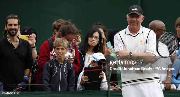 Boris Becker watches Novak Djokovic take part in a practice session during day thirteen of the Wimbledon Championships at the All England Lawn Tennis...