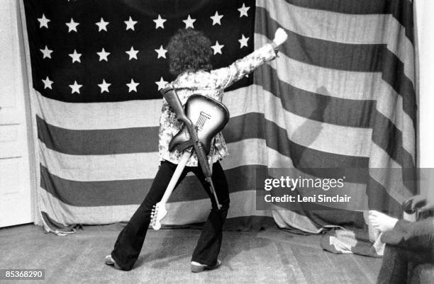 Guitarist Wayne Kramer of The group MC5 poses in front of an American flag in 1969 in East Lansing, Michigan.