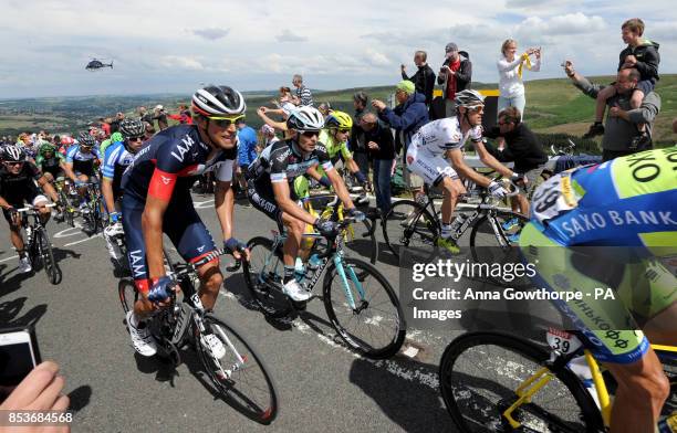 The peloton is cheered on by the crowd as stage two of the Tour de France passes over Holme Moss Moor, Yorkshire.