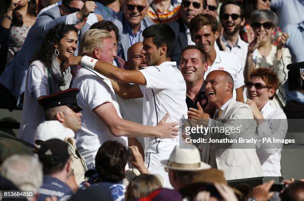 Serbia's Novak Djokovic celebrates defeating Switzerland's Roger Federer with his coach Boris Becker in the players box, following the Mens' Singles...