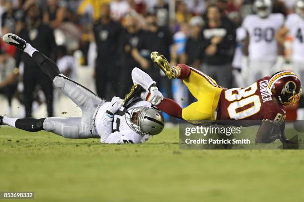 Wide receiver Jamison Crowder of the Washington Redskins is tackled by cornerback Gareon Conley of the Oakland Raiders at FedExField on September 24,...