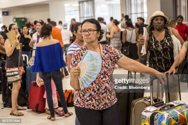 Travelers stand in line at Luis Muoz Marn International Airport in San Juan, Puerto Rico, on Monday, Sept. 25, 2017. Hurricane Maria hit the...