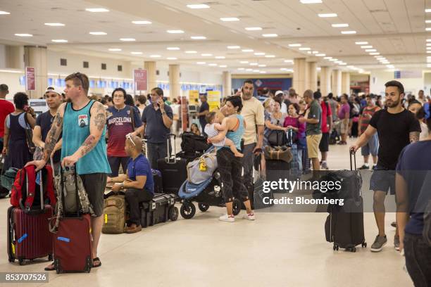 Travelers stand in line at Luis Muoz Marn International Airport in San Juan, Puerto Rico, on Monday, Sept. 25, 2017. Hurricane Maria hit the...