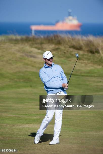 Marc Warren keeps an eye on his approach shot to the 18th hole during day two of the Aberdeen Asset Management Scottish Open at Royal Aberdeen,...