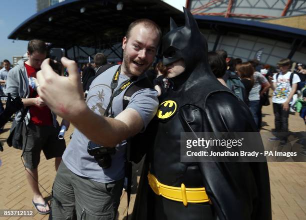 Visitor to London Film and Comic Con 2014 poses for a 'selfie' photo with a fellow visitor dressed as Batman at Earls Court Two, London, where the...