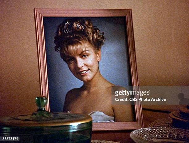 Close-up of a framed photograph of the character Laura Palmer as it sits on a table in a scene screen grab from the pilot episode of the television...