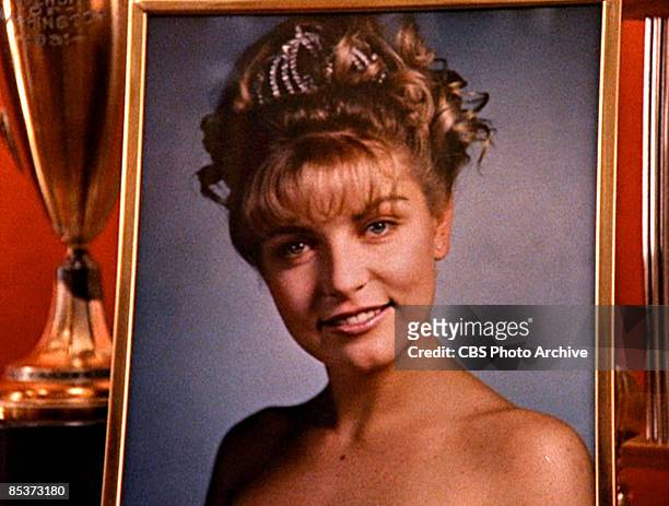 Close-up of a framed photograph of the character Laura Palmer as it sits in a display case in a scene screen grab from the pilot episode of the...