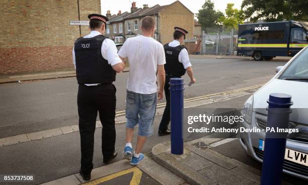 Suspect is led away as City of London Police execute a warrant at an address in Peckham, London, in connection with a criminal ring linking Russian...