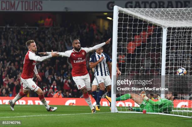 Alex Lacazette of Arsenal celebrates with teammate Aaron Ramsey after scoring the opening goal during the Premier League match between Arsenal and...