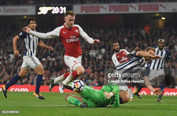 Aaron Ramsey of Arsenal is challenged by goalkeeper Ben Foster of West Bromwich Albion during the Premier League match between Arsenal and West...