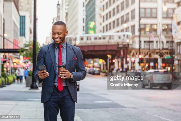 smiling business commuter using smart phone chicago streets - chicago lifestyle stock pictures, royalty-free photos & images