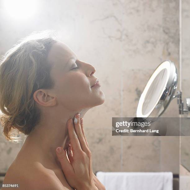 woman (36y) applying cream on neck - 9927 stock pictures, royalty-free photos & images