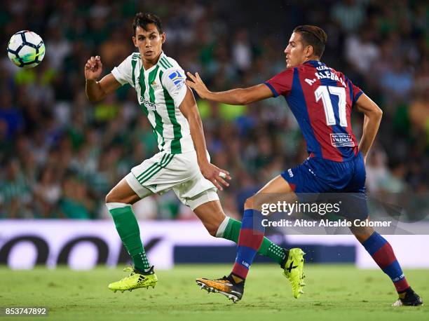 Aissa Mandi of Real Betis Balompie is pursued by Alex Alegria of Levante UD during the La Liga match between Real Betis and Levante at Estadio Benito...