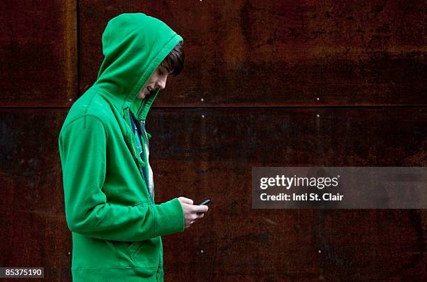 teen in hooded sweatshirt text messaging - hooded shirt ストックフォトと画像