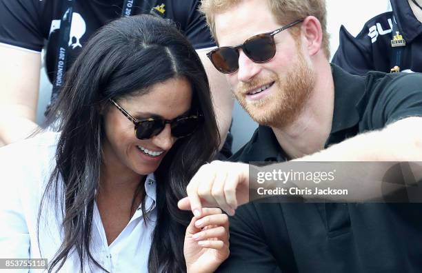 Prince Harry and Meghan Markle hold hands a Wheelchair Tennis match during the Invictus Games 2017 at Nathan Philips Square on September 25, 2017 in...