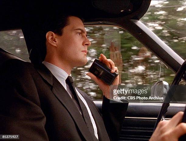 American actor Kyle MacLachlan holds a portable cassette recorder as he drives a car in a scene screen grab from the pilot episode of the television...