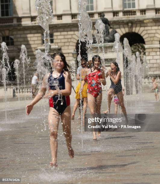 Sisters Grace and Rose Gadsby from south London, with their friend Bonnie Thomas from Wales, playing in the water fountains at Somerset House,...
