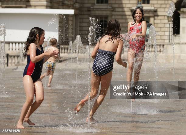 Sisters Grace and Rose Gadsby from south London, with their friend Bonnie Thomas from Wales, playing in the water fountains at Somerset House,...