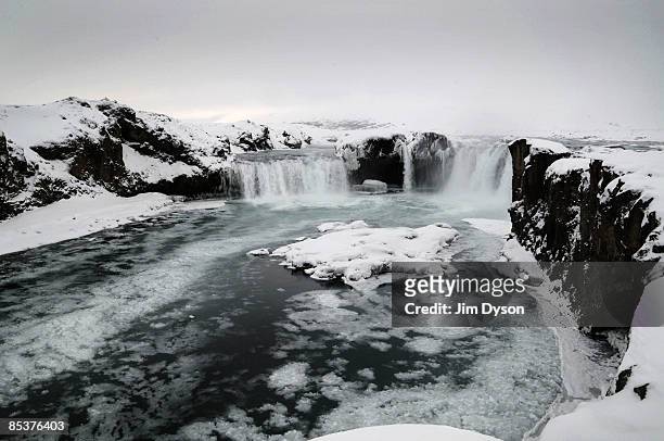 The twin waterfall of Godafoss cascades through the snow covered landscape on February 23, 2009 in north Iceland. A country of glacial and volcanic...