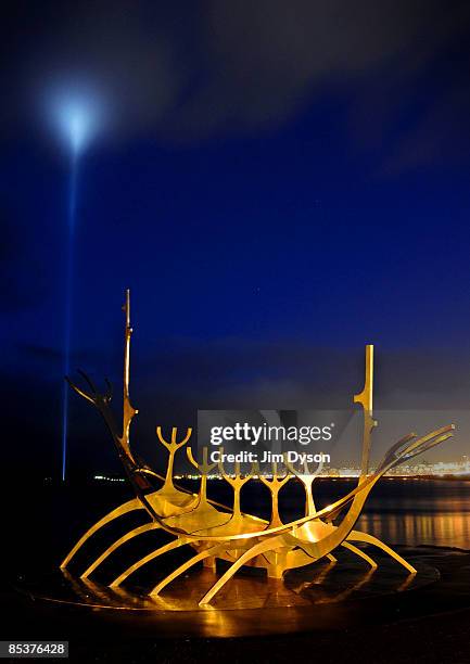 The viking boat sculpture on Reykjavik harbour is illuminated at night as the 'Imagine Peace' Light by Yoko Ono lights up the clouds in the...