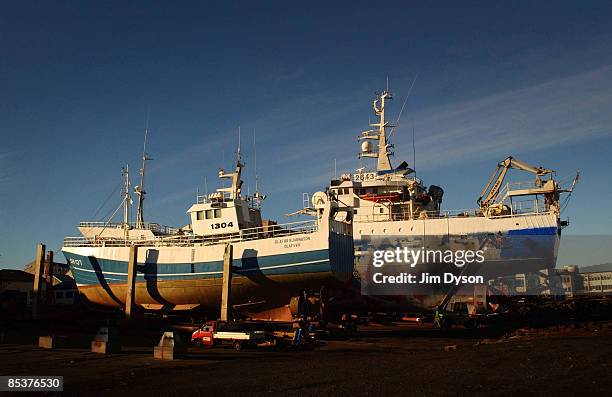 Pair of fishing boats undergo maintenance out of water in Reykjavik harbour on October 21, 2004 in Reykjavik, Iceland. A country of glacial and...