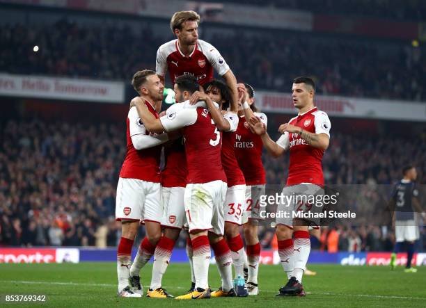 Alexandre Lacazette of Arsenal celebrates with team mates as he scores their second goal from a penalty during the Premier League match between...