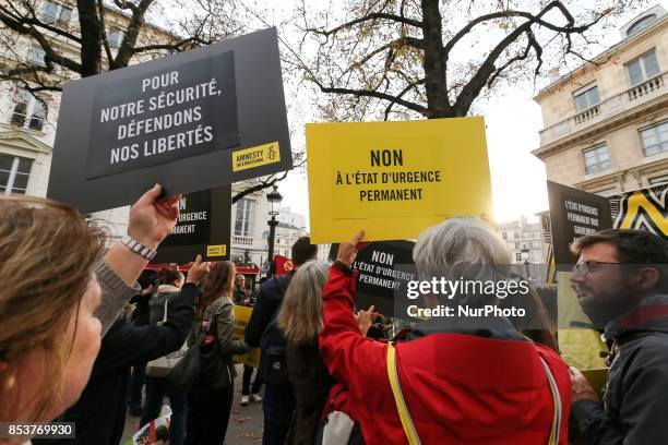 Man holds a bag reading 'For our security, let us defend our freedom' during a protest against 'permanent state of emergency' in Paris on September...